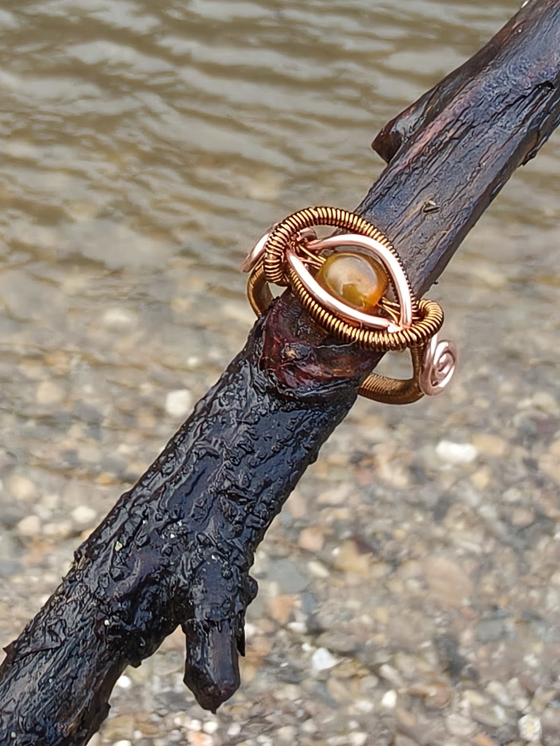 Anillo de cobre cálido con brillo ámbar