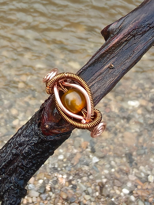 Anillo de cobre cálido con brillo ámbar